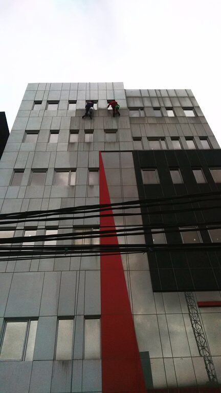 Pembersihan kaca dan ACP gedung dengan gondola