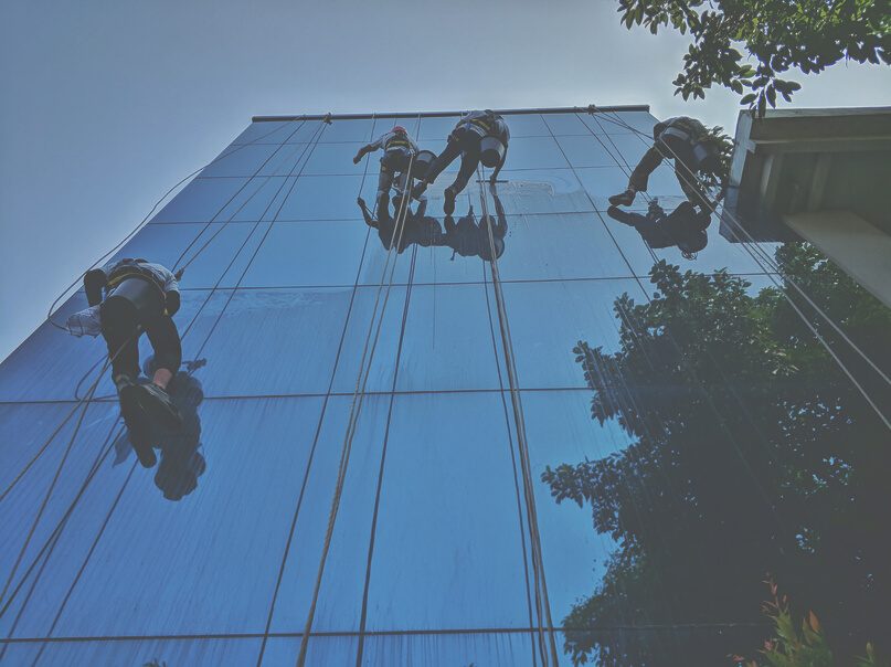 Petugas PTCRM membersihkan kaca gedung bertingkat dengan gondola