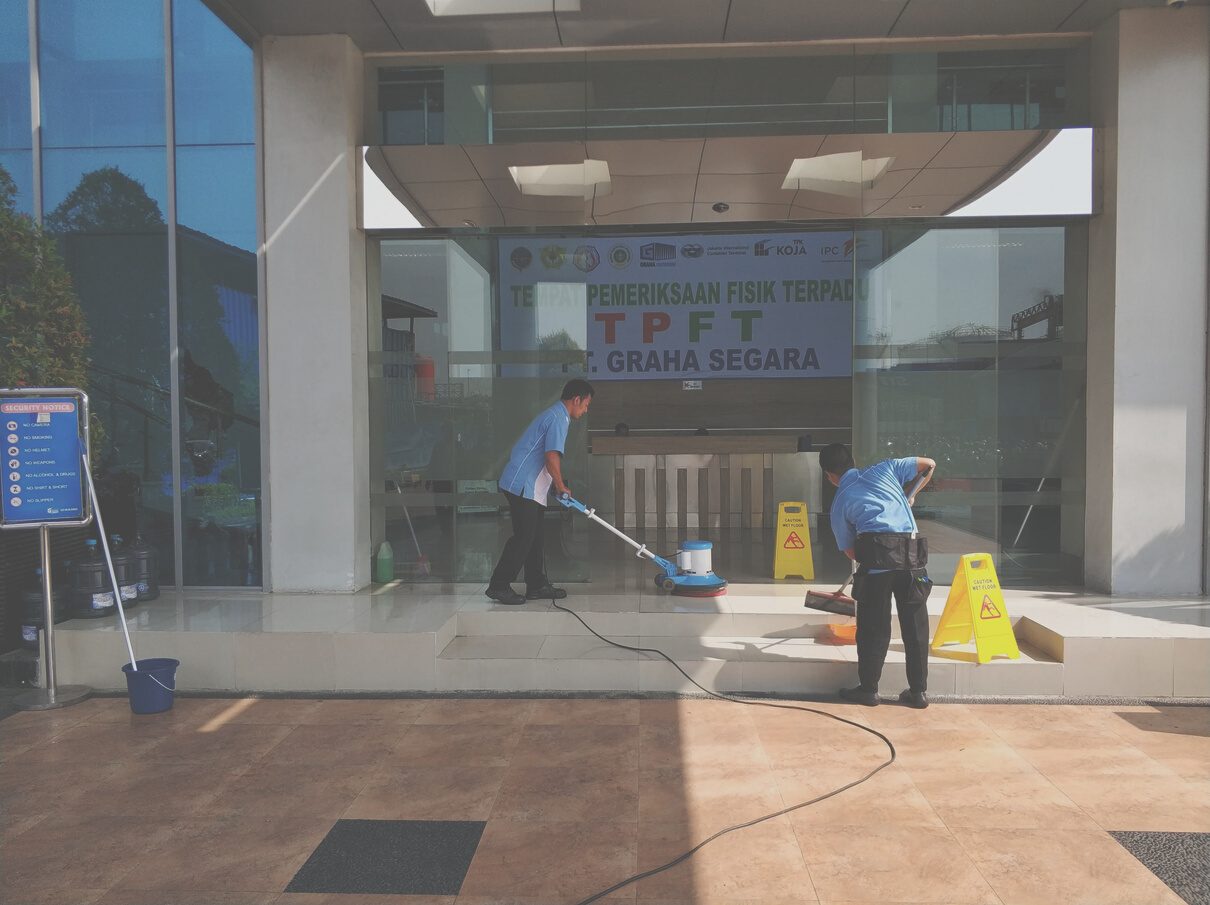 Petugas PTCRM memoles lantai lobi gedung kantor